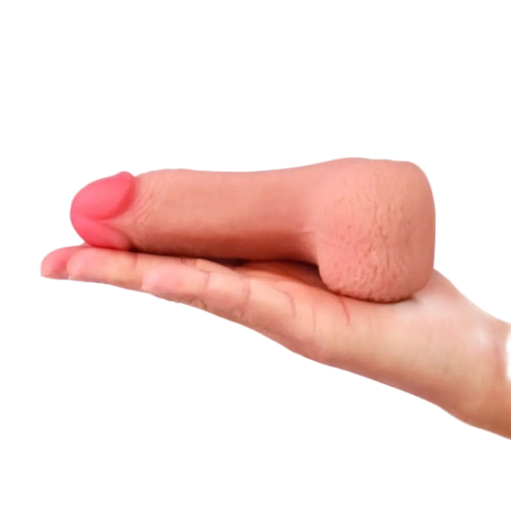 Love toy 5 inch dual layer TPE packing penis form laying on the palm of an outstretched hand